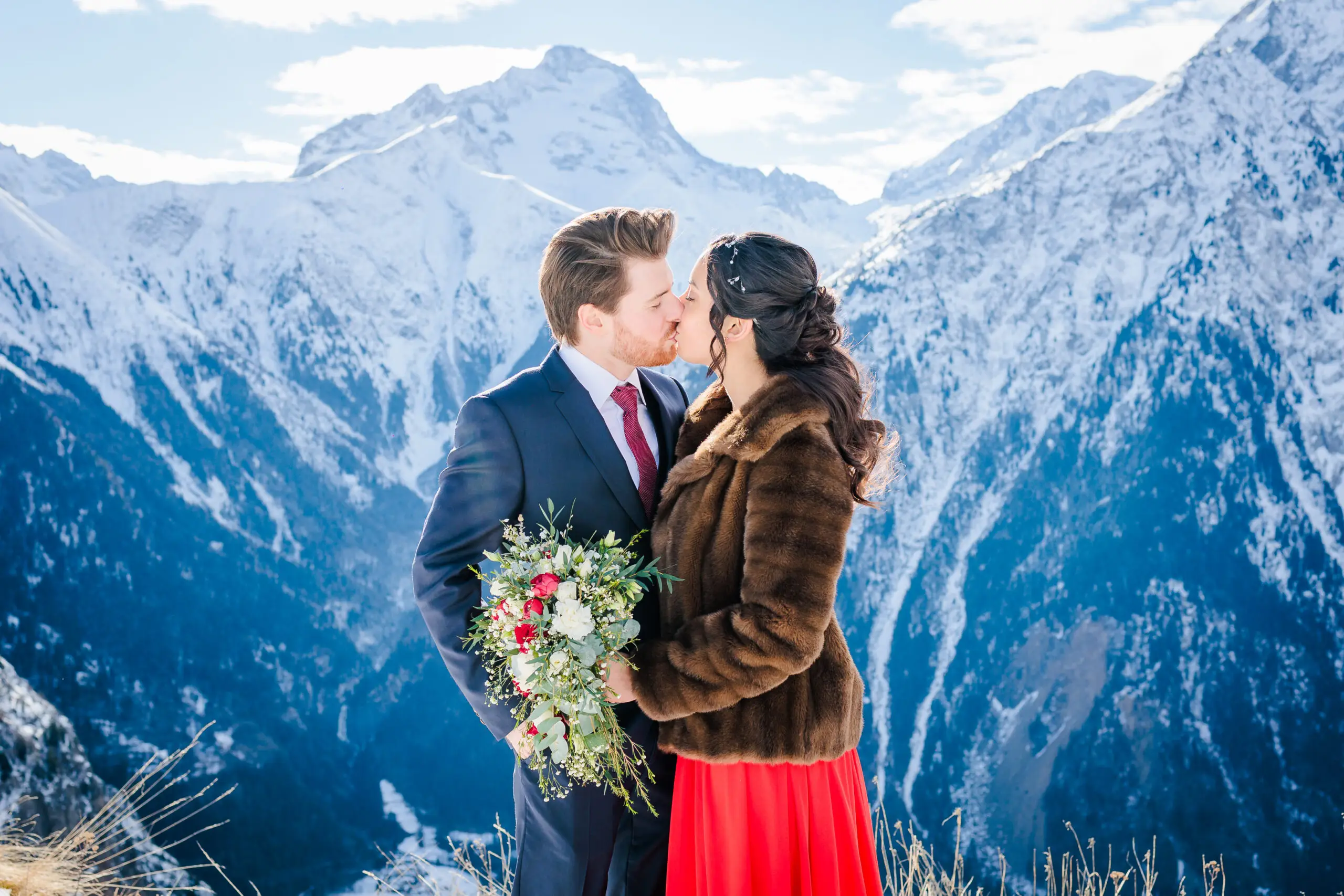 Mariés s'embrassant devant les Montagnes enneigées, photo prise par Florian Fauvarque photographe mariage à Grenoble en Isère