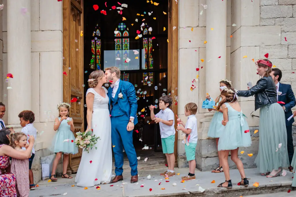 Mariés s'embrassant à la sortie d'Église, photo prise par Florian Fauvarque photographe mariage à Grenoble en Isère
