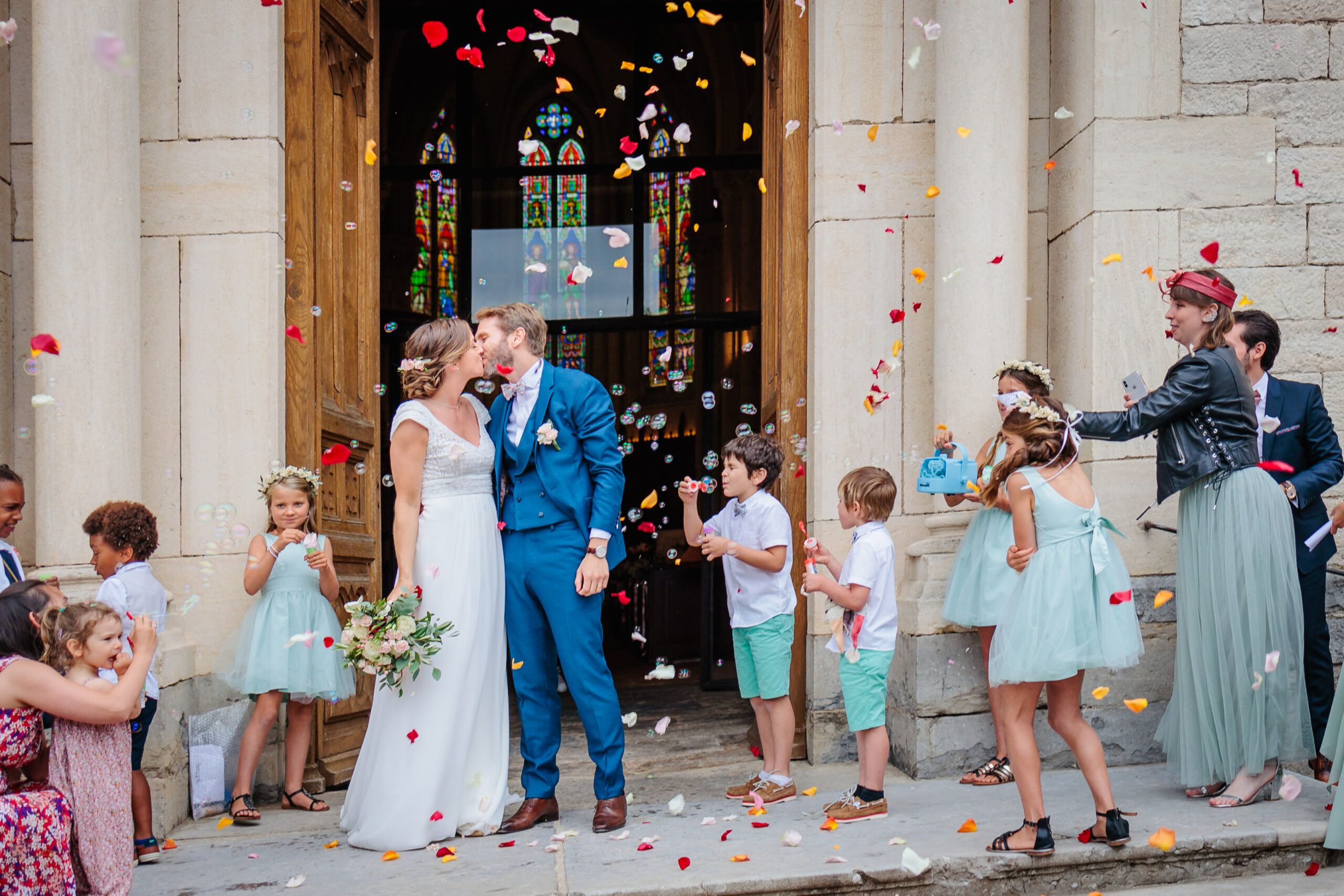 Mariés s'embrassant à la sortie d'Église, photo prise par Florian Fauvarque photographe mariage à Grenoble en Isère