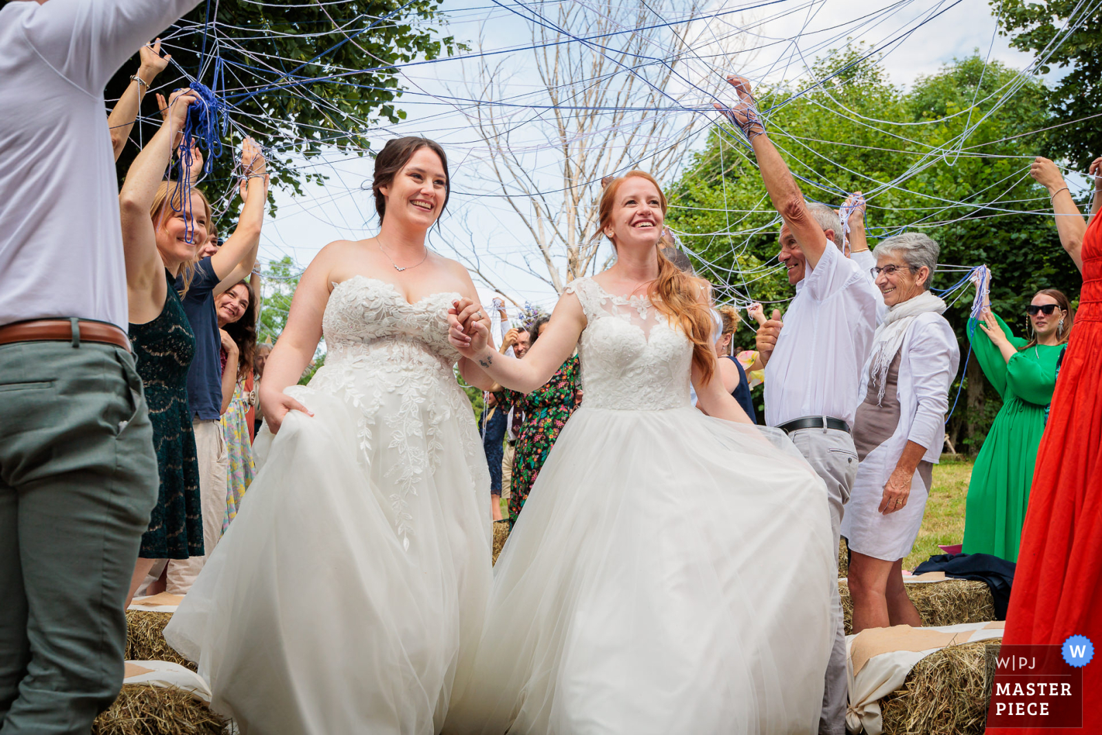 Deux mariées souriantes marchent ensemble, photo prise par Florian Fauvarque photographe de mariage à Grenoble et en Isère.