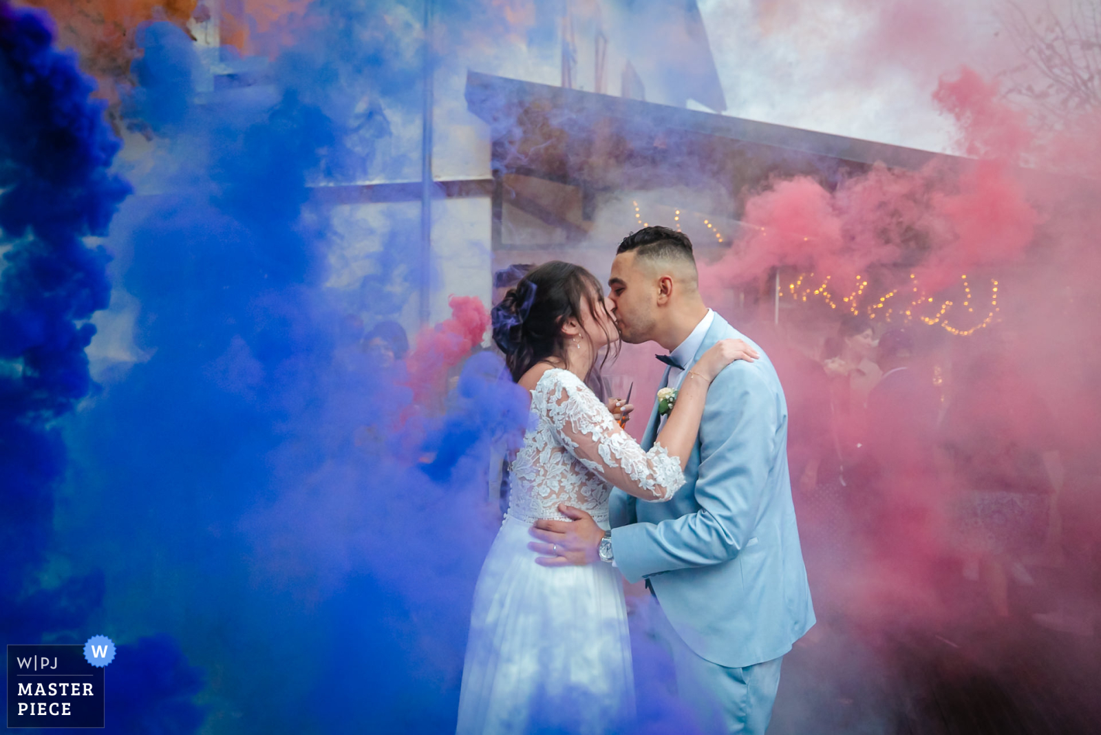 Photo gagnante WPJA Mariés s'embrassant sous les fumigènes, photo prise par Florian Fauvarque photographe de mariage à Grenoble en Isère