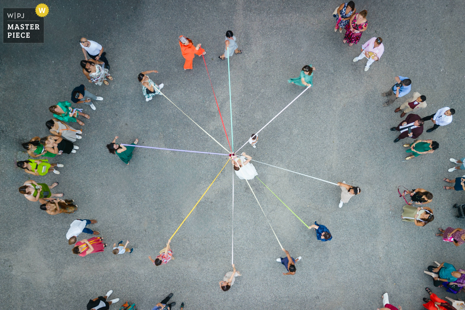 Jeu de la ronde des rubans prise en vue de dessus au drone, photo prise par Florian Fauvarque Photographe de mariage à Grenoble en Isere, récompensée d'une médaille d'or à la WPJA