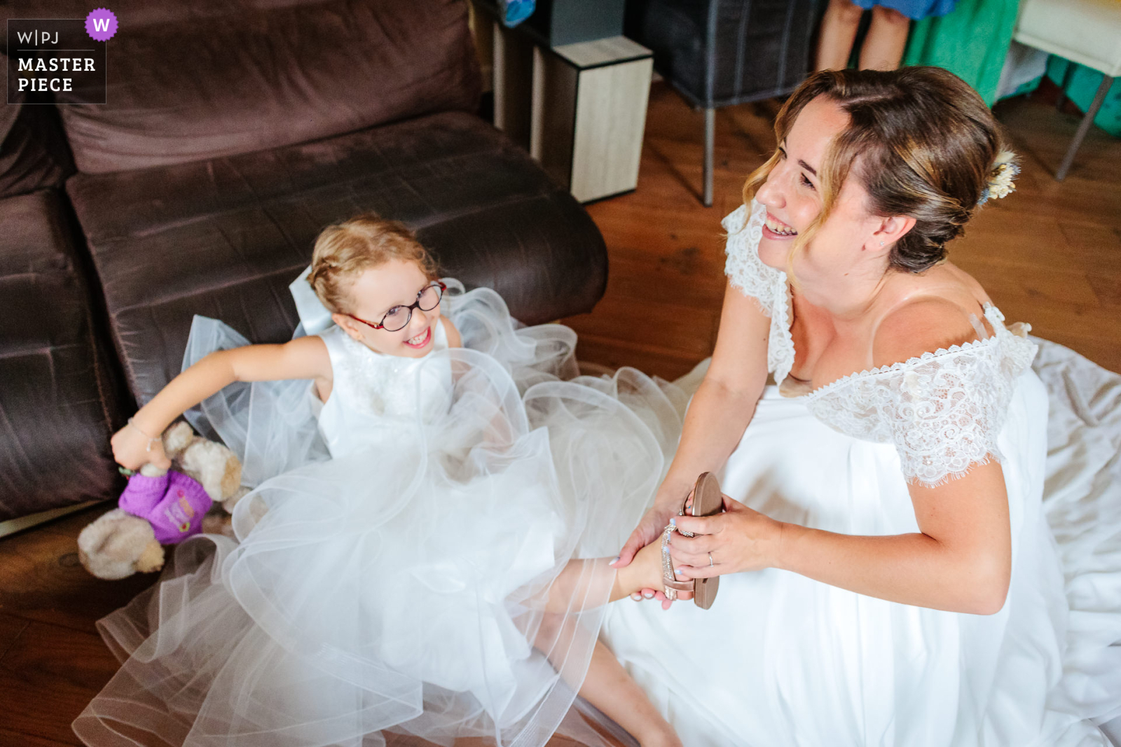 La fille de la mariée tombe en riant lors des préparatifs, photo prise par Florian Fauvarque photographe de mariage. Élu WPJA Master Piece Purple par WPJA