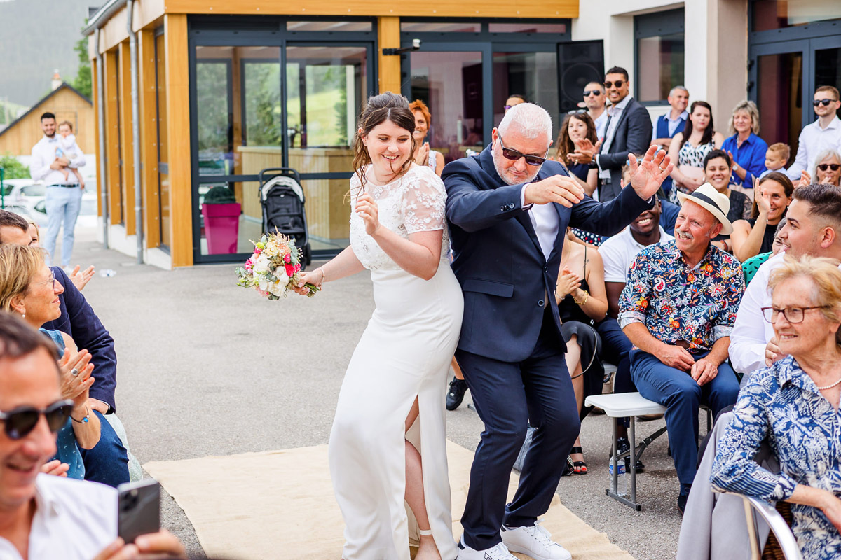 La mariée et son père danse dos à dos lors de l'entrée de la cérémonie laïque, photo prise par Florian Fauvarque photographe de mariage. Utiliser par Fearless.