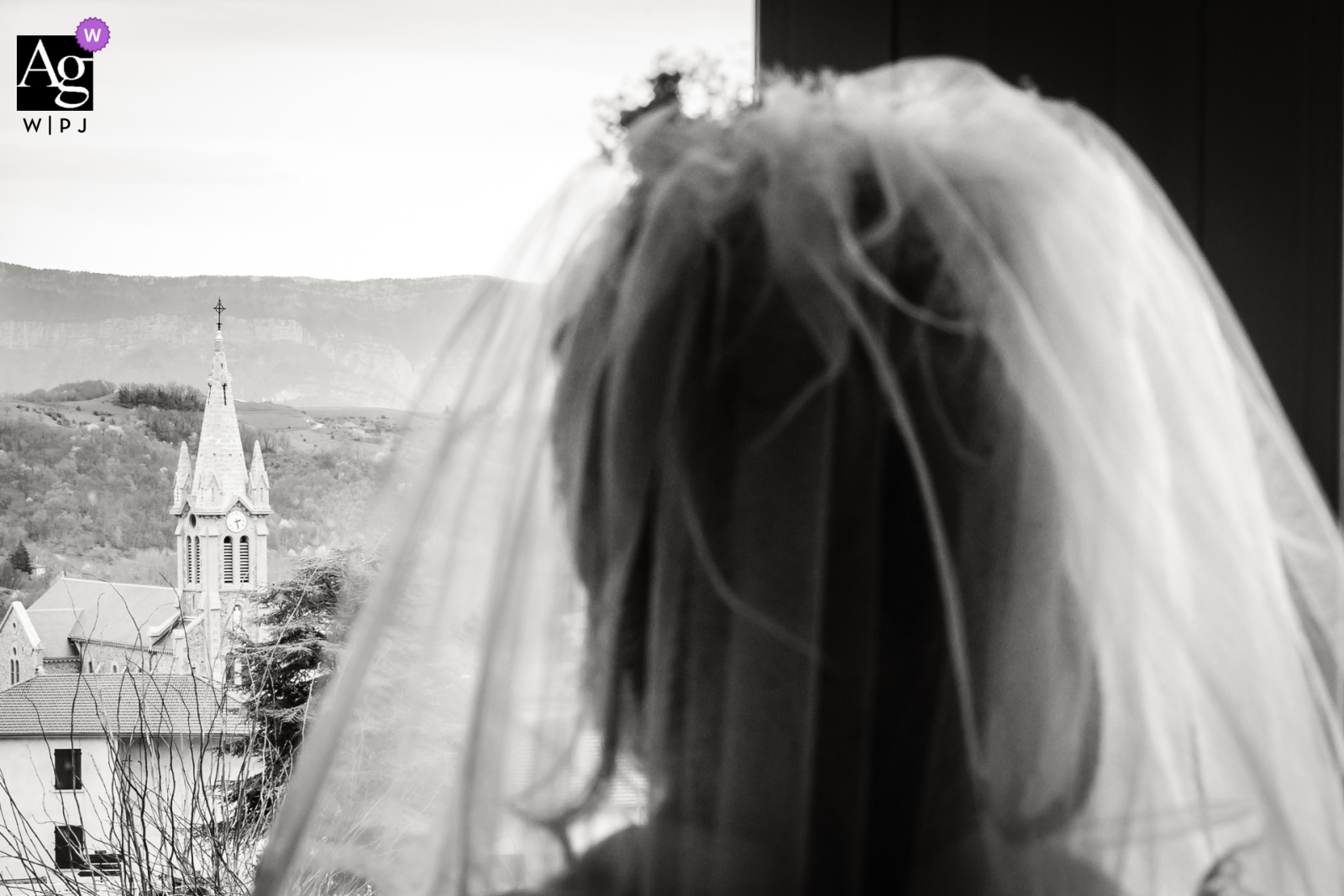 Une mariée de dos regarde la tour de l'église, photo prise par Florian Fauvarque photographe de mariage. Élu Artistic Guild Purple récompensé par WPJA