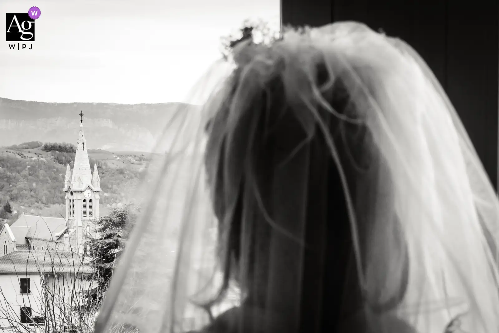 Une mariée de dos regarde la tour de l'église, photo prise par Florian Fauvarque photographe de mariage. Élu Artistic Guild Purple récompensé par WPJA