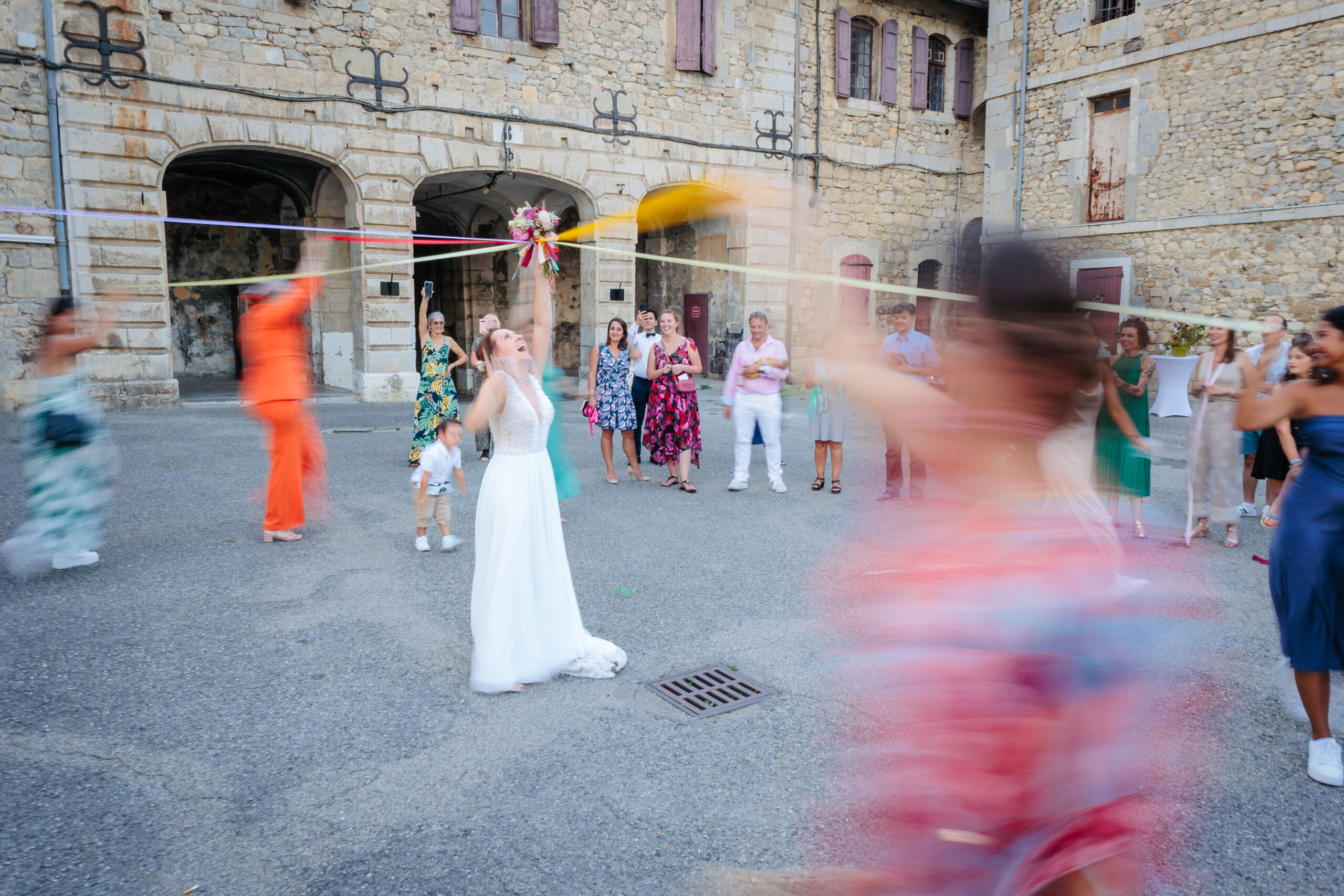 Mariée faisant le jeu de la ronde des rubans, photo prise par Florian Fauvarque photographe de mariage écoresponsable à Grenoble
