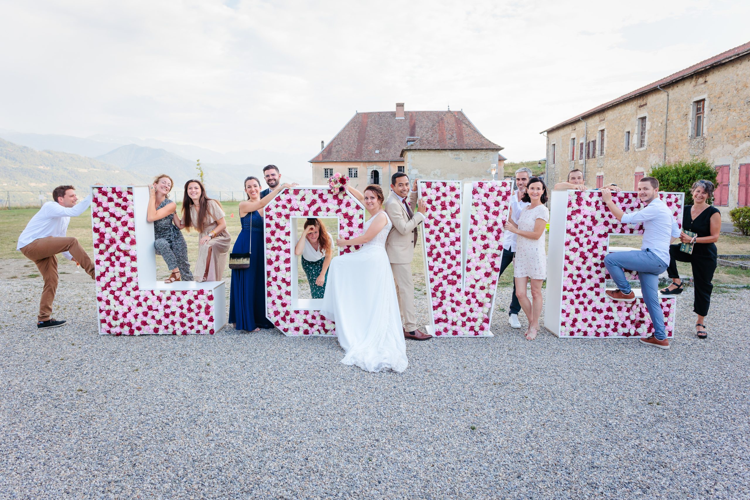 Photo de groupe avec panneau Love, photo prise par Florian Fauvarque photographe de mariage à Grenoble et en Isère