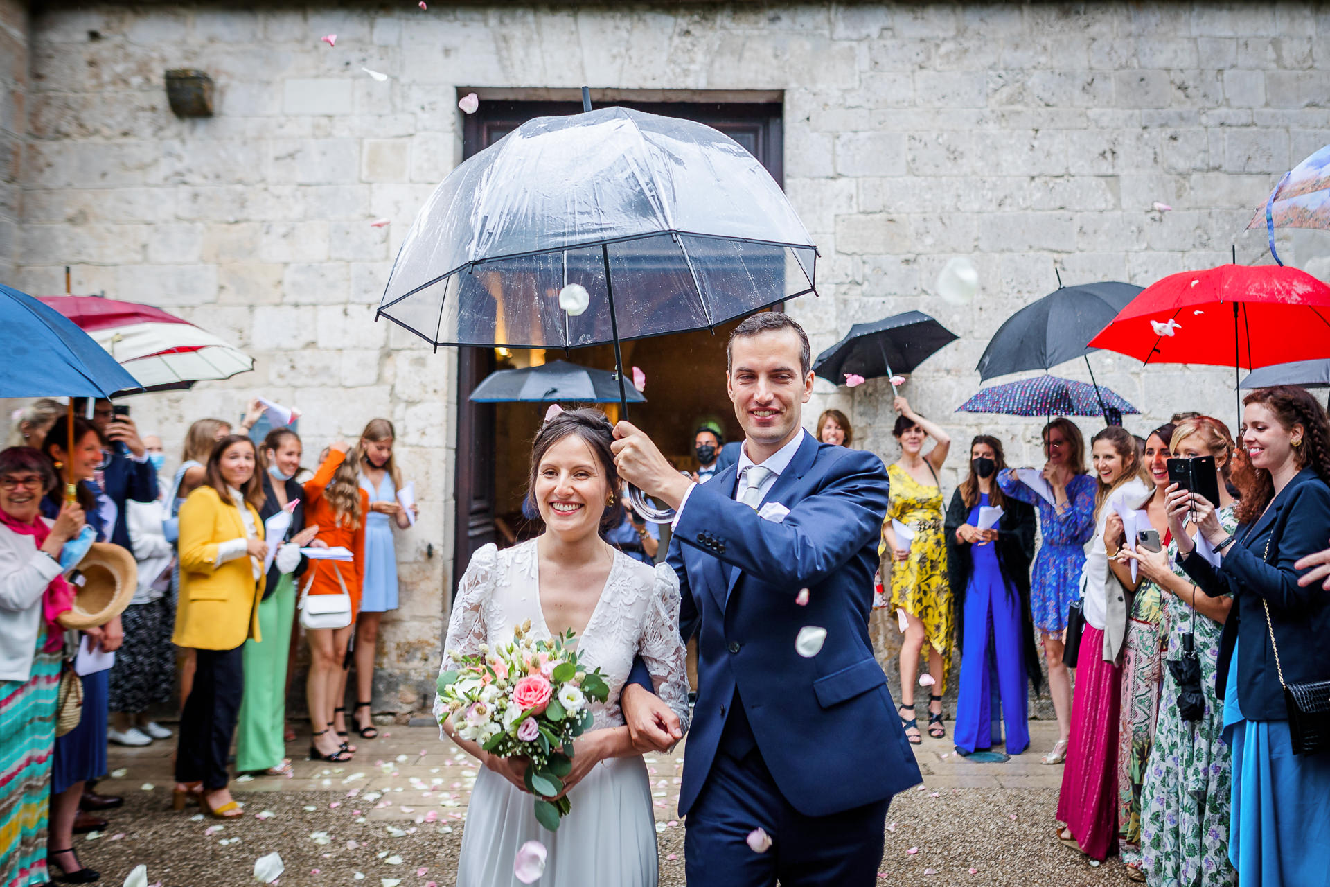 Sortie d'église sous la pluie, photo prise par Florian Fauvarque photographe de mariage à Grenoble et en Isère