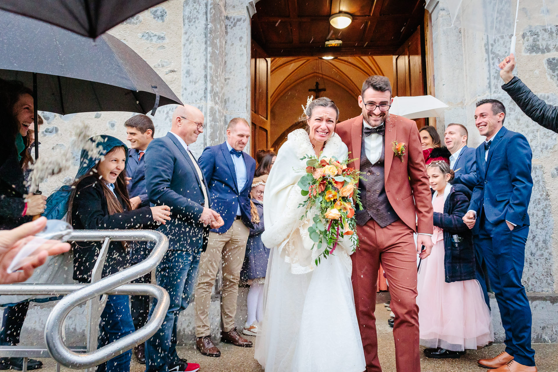 Sortie d'église sous la pluie, photo prise par Florian Fauvarque photographe de mariage à Grenoble et en Isère