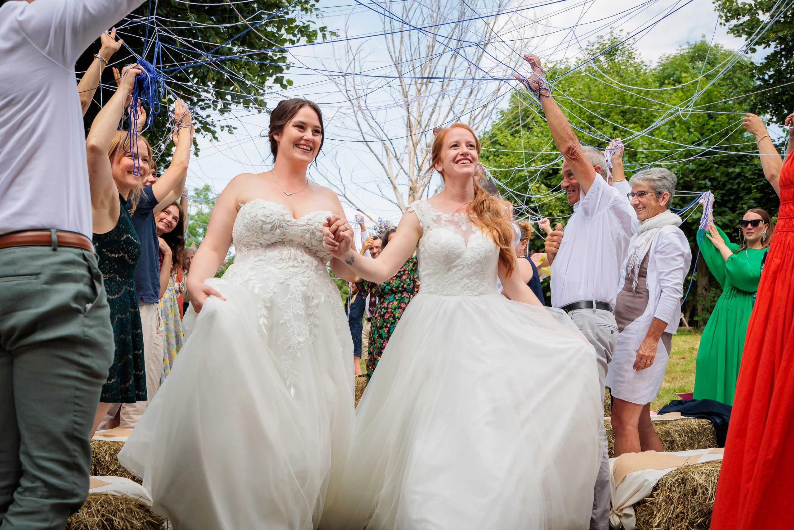 Sortie de cérémonie des mariées sous des pelotes de laines, photo prise par Florian Fauvarque photographe de mariage à Grenoble et en Isère