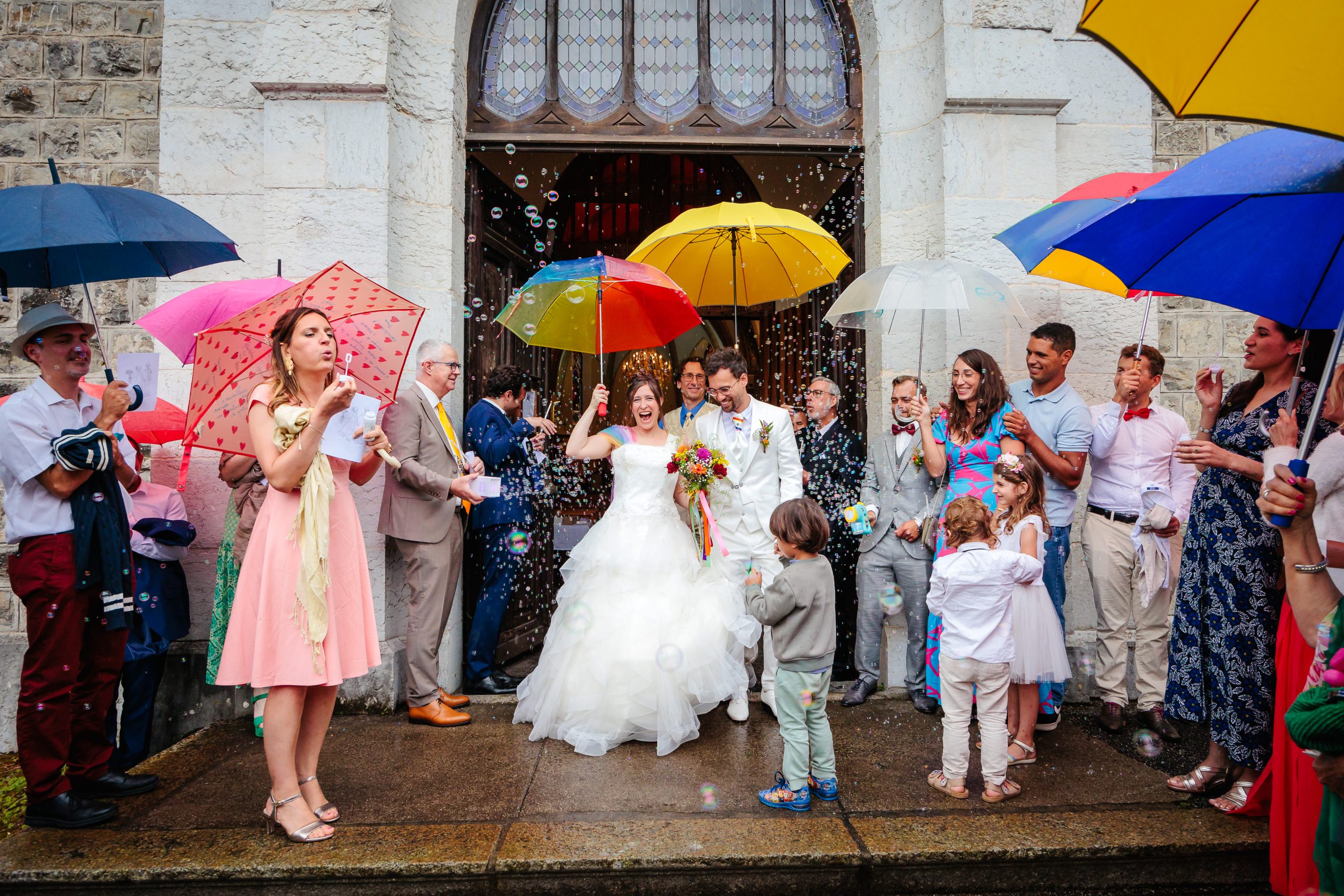 Sortie de l'église sous un nuage de bulles, photo prise par Florian Fauvarque photographe de mariage à Grenoble et en Isère