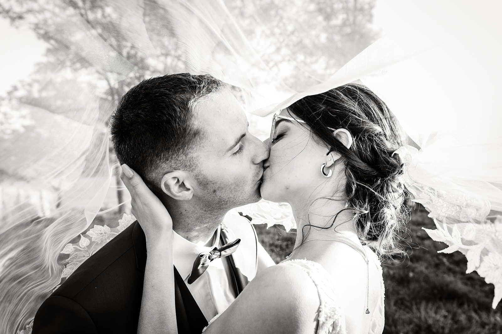 Baiser sous le voile de la mariée, photo prise par Florian Fauvarque photographe de mariage à Grenoble et en Isère