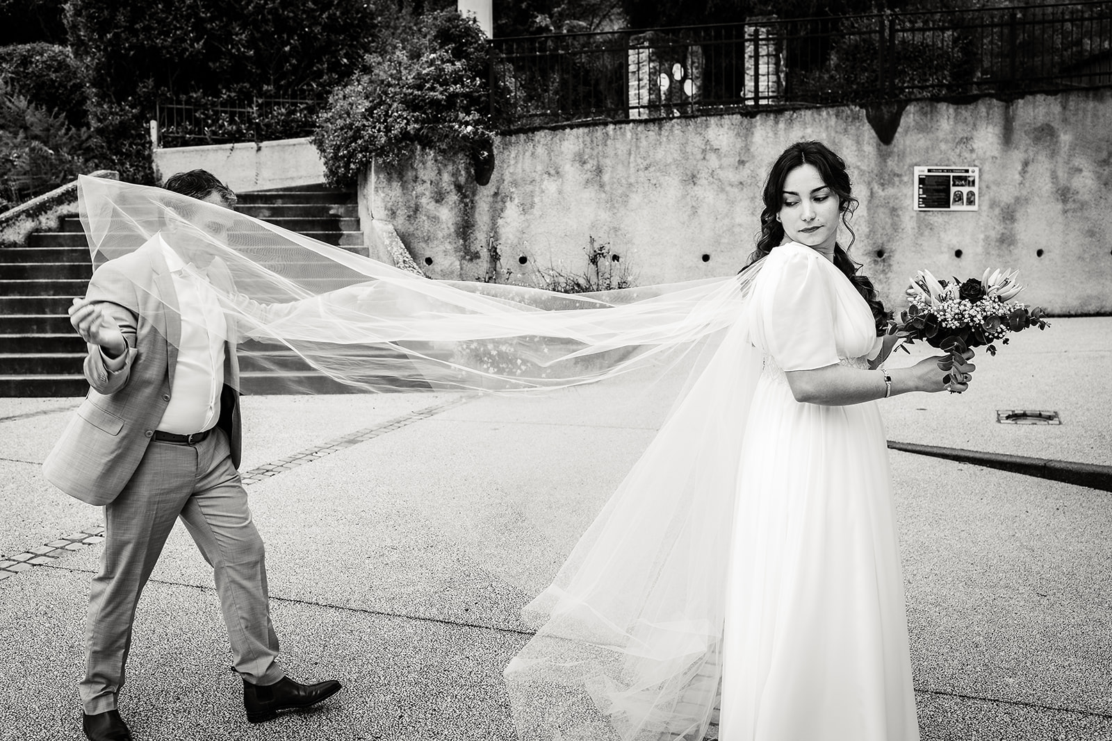 Le père de la mariée l'aide à ajuster son voile, photo prise par Florian Fauvarque photographe de mariage à Grenoble en Isère.