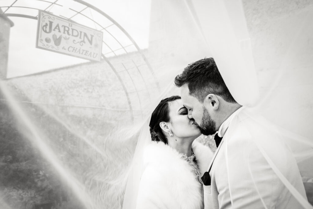 Les mariés s'embrassent sous le voile de la mariée, photo prise par Florian Fauvarque photographe de mariage à Grenoble et en Isère