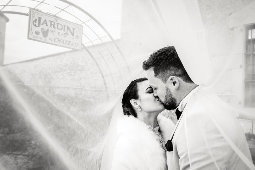 Les mariés s'embrassent sous le voile de la mariée, photo prise par Florian Fauvarque photographe de mariage à Grenoble et en Isère