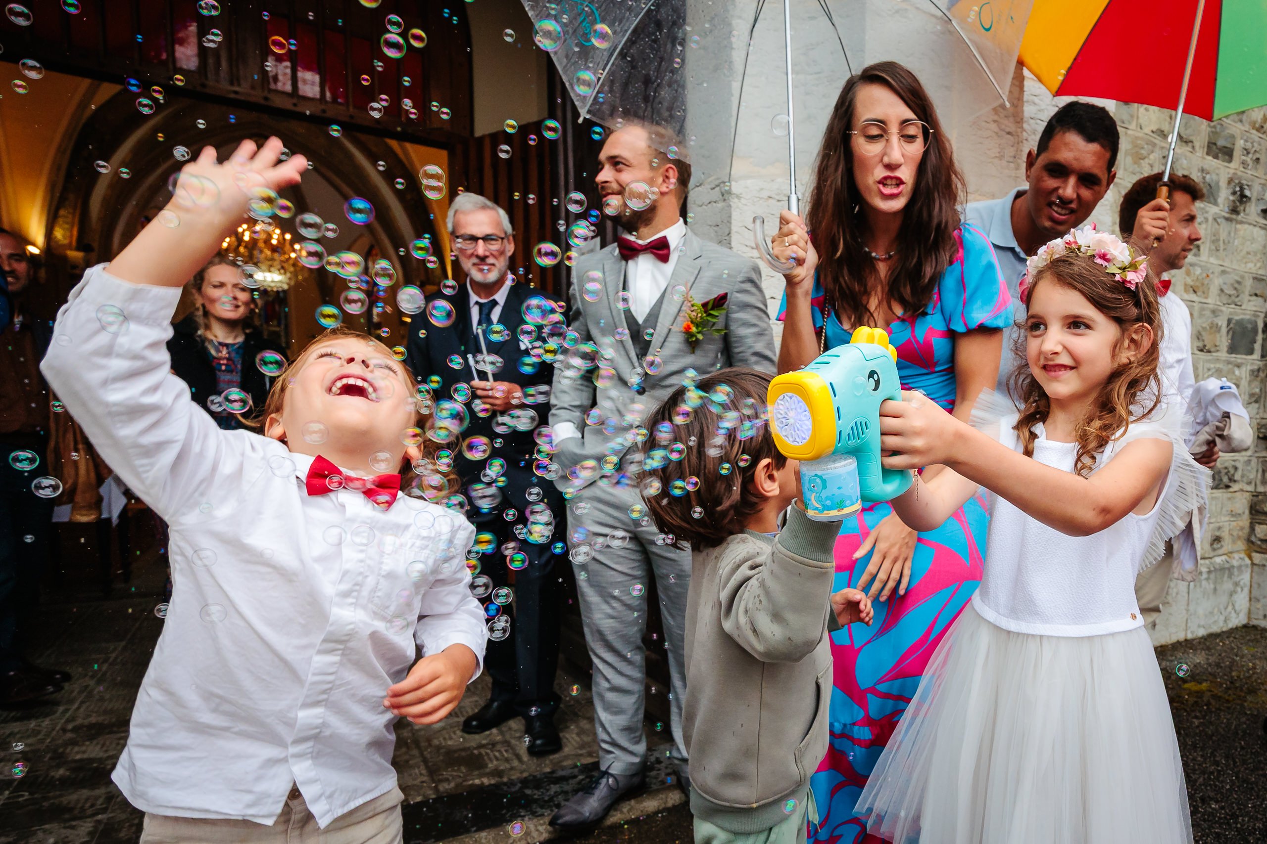 Enfants jouant avec des bulles à la sortie de l'église, photo prise par Florian Fauvarque photographe de mariage à Grenoble en Isère