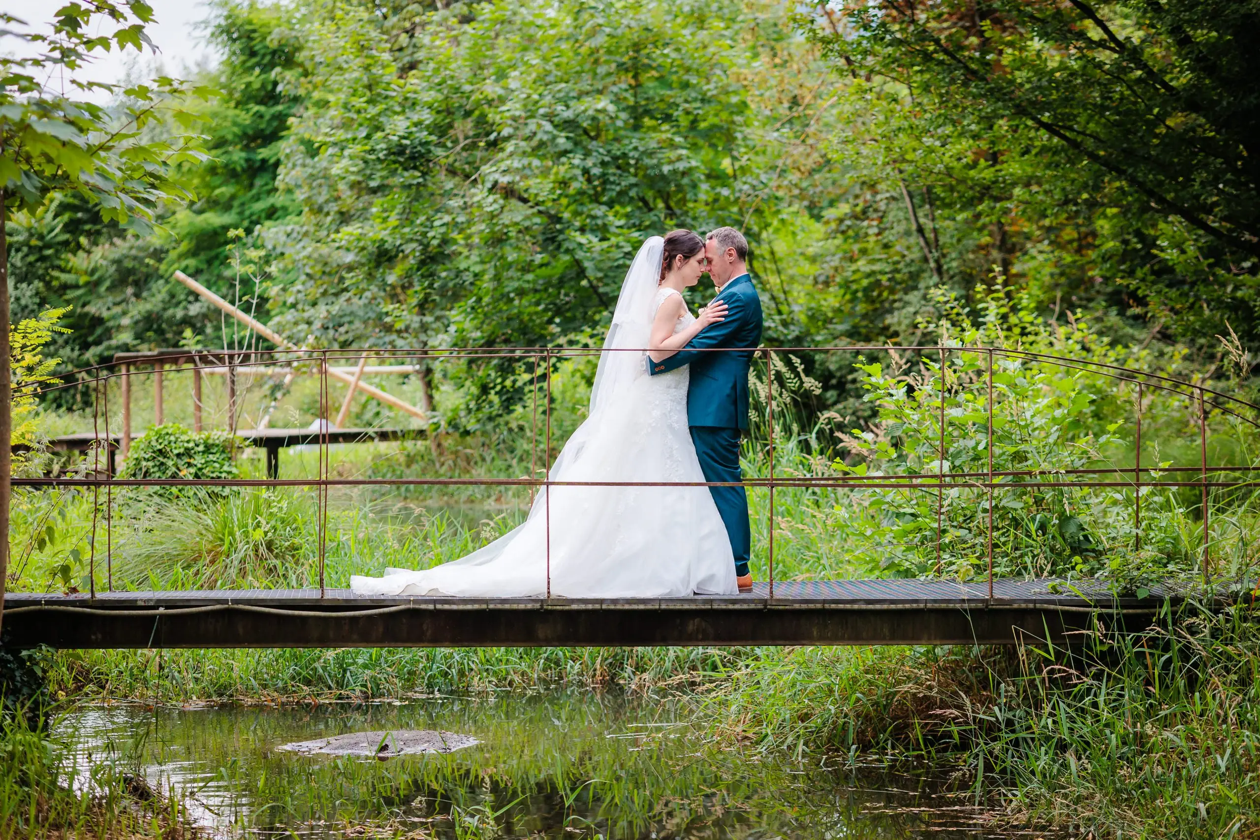 Mariage romantique sur un pont en nature verdoyante, photo prise par Florian Fauvarque photographe de mariage à Grenoble et en Isère