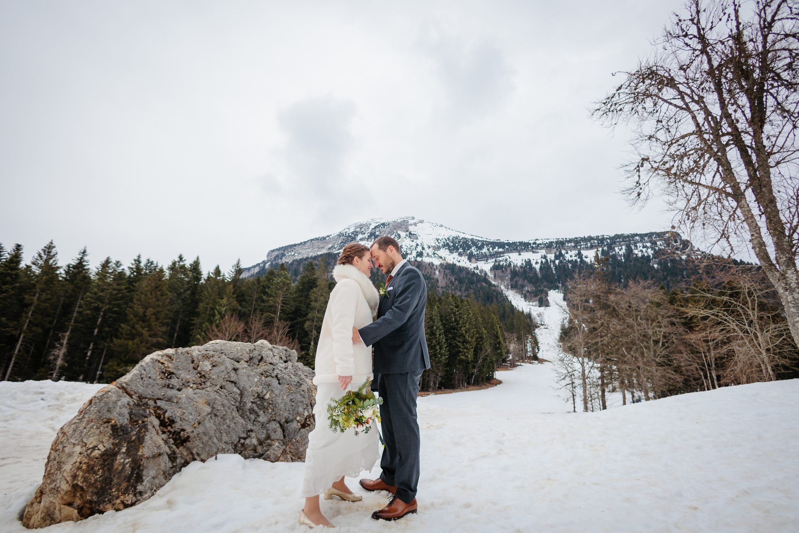 Séance couple de mariés dans la neige à la montagne. Photo prise par Florian Fauvarque, photographe de mariage écoresponsable à Grenoble en Isère.