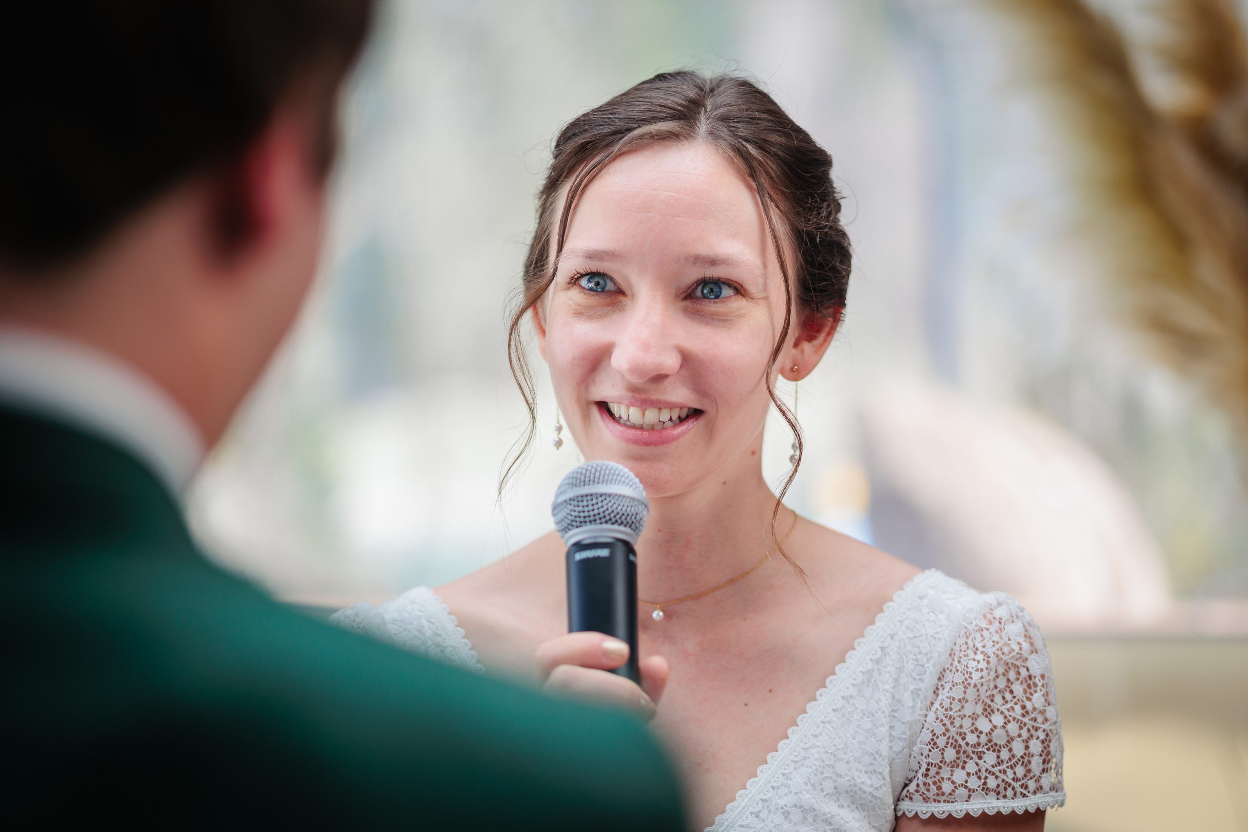 Mariée souriante parlant au micro lors de la cérémonie, photo prise par Florian Fauvarque photographe de mariage à Grenoble et en Isère