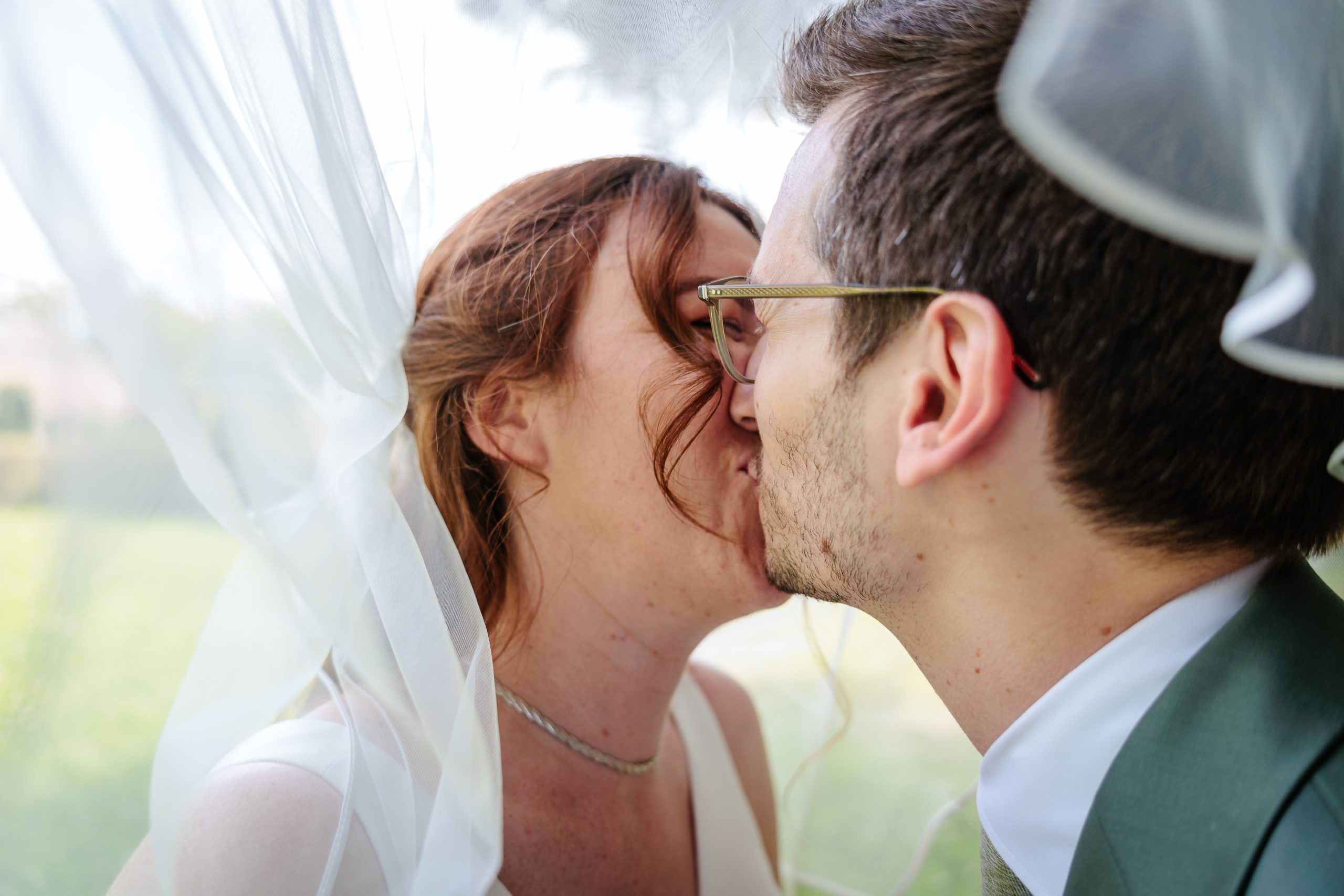 Couple s'embrassant sous un voile blanc, photo prise par Florian Fauvarque photographe de mariage à Grenoble et en Isère