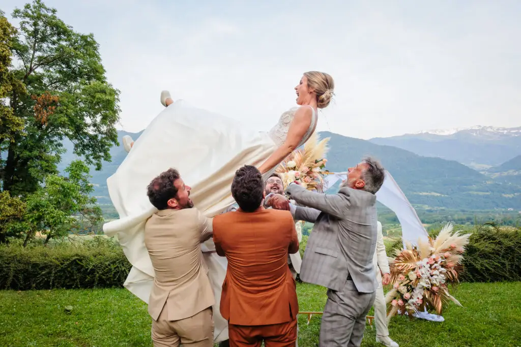 Mariée portée par des amis dans un paysage alpin, photo prise par Florian Fauvarque photographe de mariage à Grenoble et en Isère