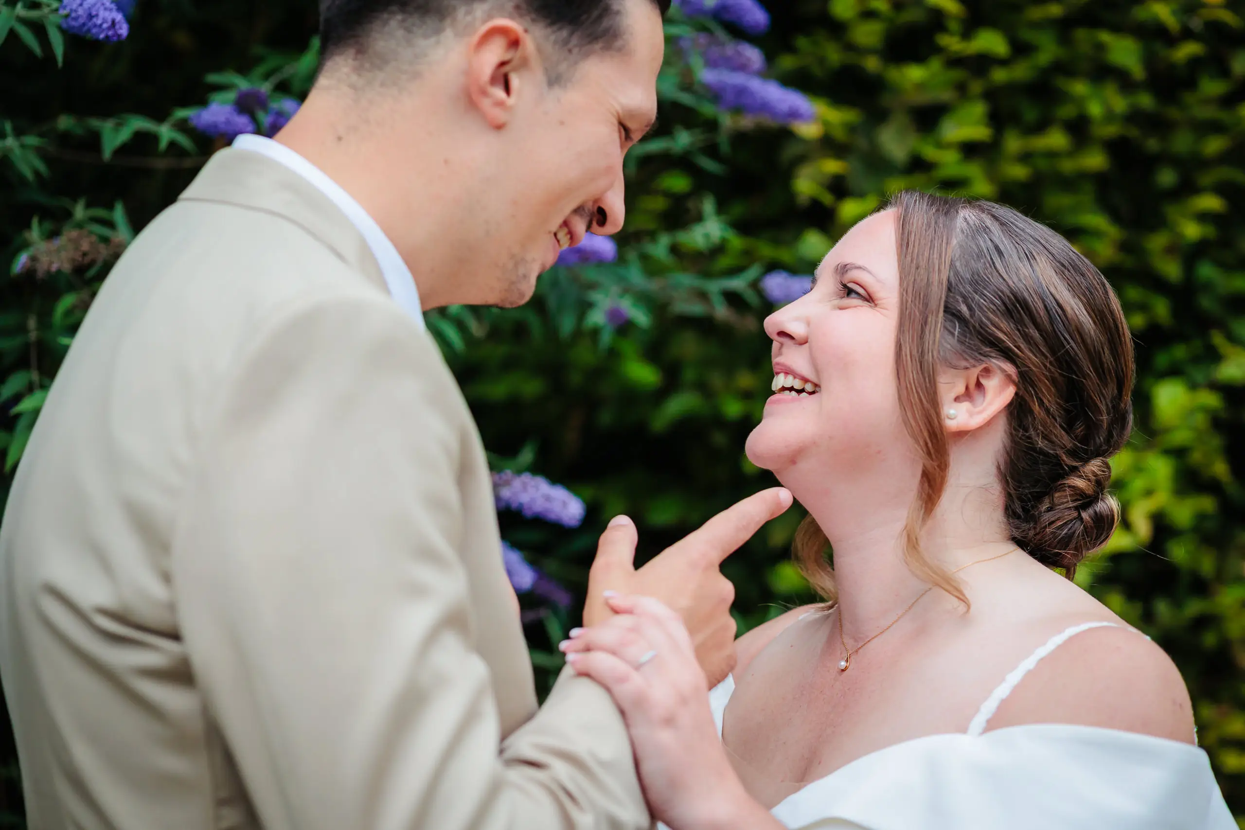 Mariés souriants dans un jardin fleuri, photo prise par Florian Fauvarque photographe de mariage à Grenoble et en Isère